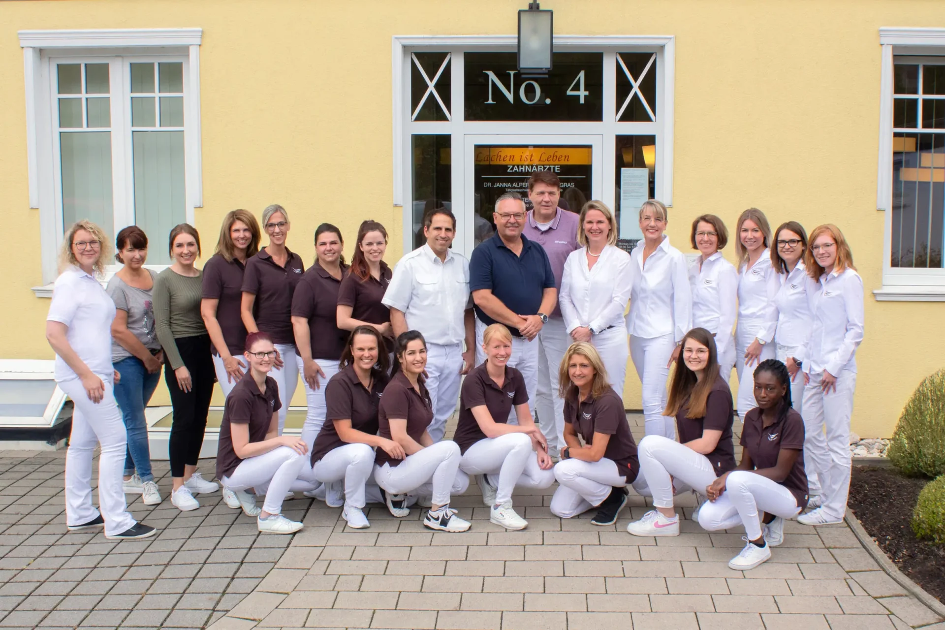 Praxisteam der Zahnarztpraxis Dr. Alpers vor dem Praxisgebäude